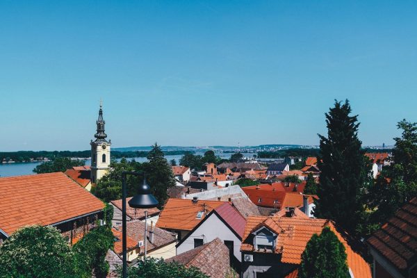 Kako pratiti vremenske uslove tokom leta a group of buildings with trees and a body of water in the background